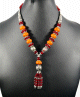 Collier ethnique artisanal avec pierres orange et bordeaux agremente de breloques et d'armatures argentees