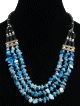 Collier ethnique artisanal trois rangs imitation quartz bleu agremente de perles en metal et de tubes noirs