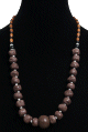 Collier ethnique artisanal imitation pierres difformes marrons agencees de perles argentees et en bois avec une grosse boule au milieu