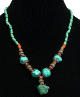 Collier ethnique artisanal imitation quatre pierres difformes turquoises agrementees de perles en metal, vertes et en bois