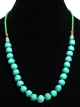 Collier ethnique artisanal imitation pierres rondes turquoises agencees de perles argentees, vertes et en bois
