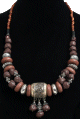 Magnifique collier ethnique artisanal imitation pierres marrons, agencees d'armatures et de perles et agremente d'une grosse boule argentee gravee et de breloques