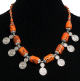 Collier ethnique artisanal cylindres imitation corail orange avec armatures en metal argente cisele agremente de pendentifs tourbillon spirale argentes